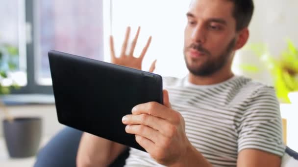 Glücklicher Mann mit Tablet-PC mit Videoanruf zu Hause — Stockvideo