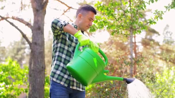 Muž středního věku zalévání květiny na zahradě — Stock video
