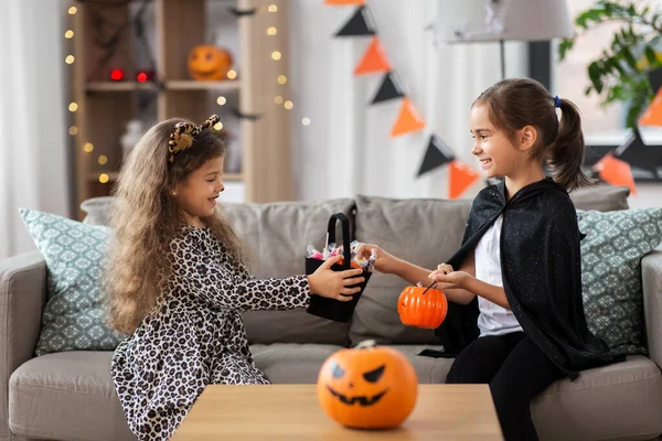 Meninas em trajes de Halloween com doces em casa — Fotografia de Stock