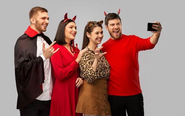 Šťastný přátelé v halloween kostýmy přičemž selfie — Stock fotografie