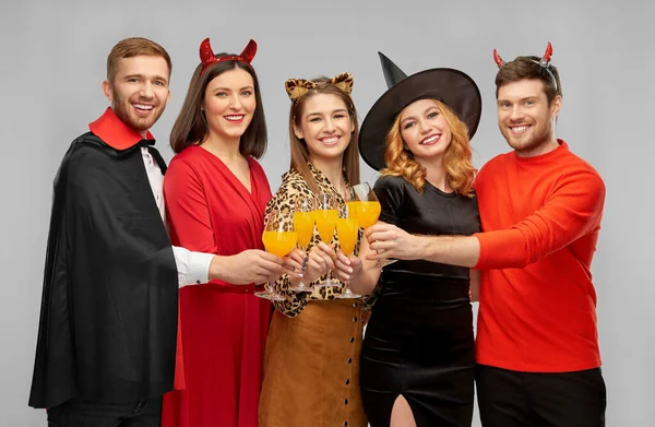 Szczęśliwy przyjaciele w halloween kostiumy na szarości — Zdjęcie stockowe
