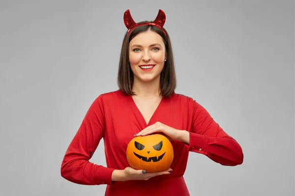 Žena v halloween kostýmu ďábla s dýní — Stock fotografie