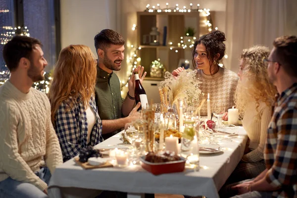 Glückliche Freunde mit Rotwein auf Weihnachtsfeier — Stockfoto