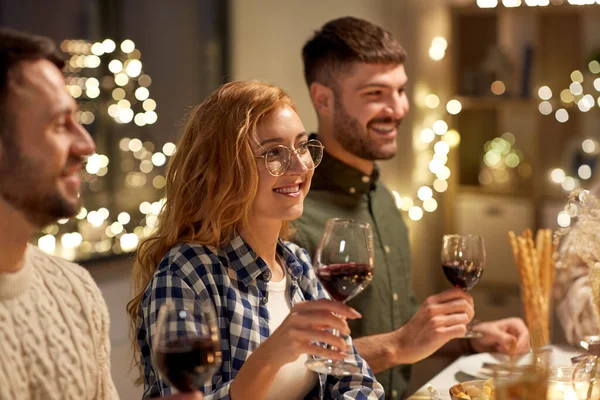 Glückliche Freunde, die auf der Weihnachtsfeier Rotwein trinken — Stockfoto
