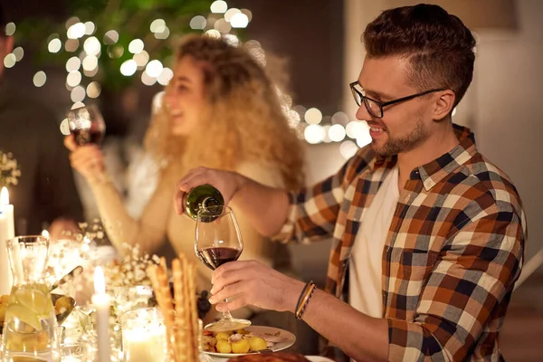 Чоловік наливає червоне вино на склянку на вечірці — стокове фото