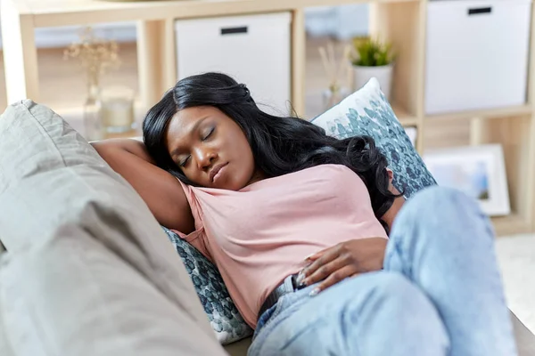 Mujer afroamericana durmiendo en sofá en casa — Foto de Stock