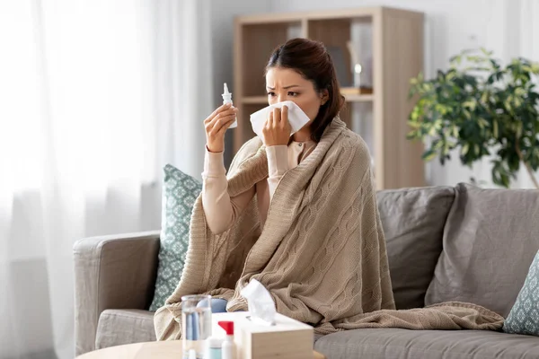 Enfermo asiático mujer con nasal spray medicina en casa —  Fotos de Stock