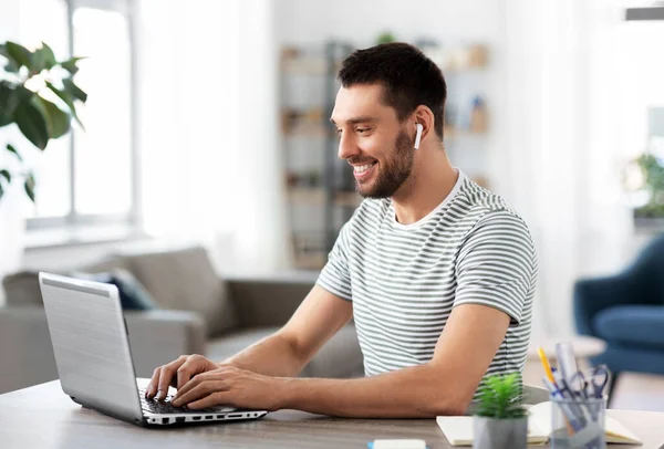 Uomo con laptop e auricolari a casa ufficio — Foto Stock