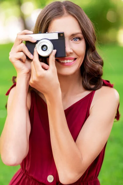 Ευτυχισμένη γυναίκα με φωτογραφική μηχανή φωτογράφηση στο πάρκο — Φωτογραφία Αρχείου