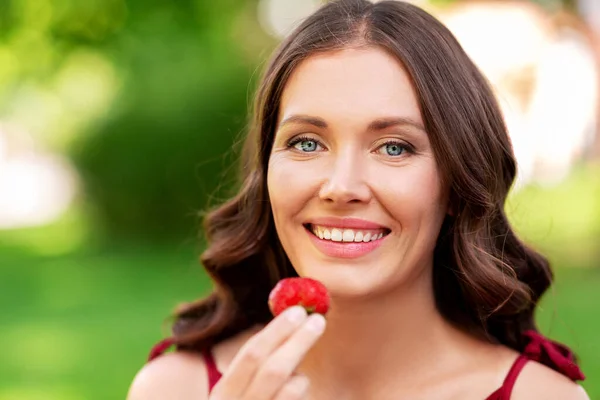 여름 공원에서 딸기를 먹는 행복 한 여성 로열티 프리 스톡 사진