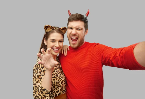 Feliz pareja en halloween trajes tomando selfie —  Fotos de Stock