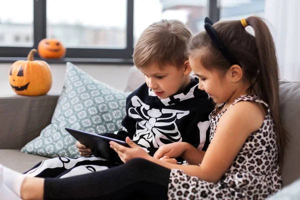 Дети в костюмах на Хэллоуин с планшетным ПК дома — стоковое фото