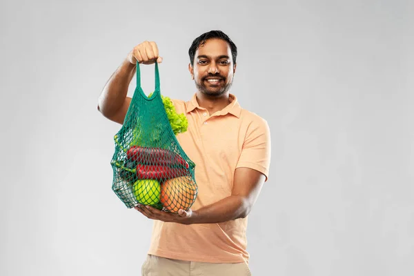 Happy indian man with food in reusable net tote — Stock Photo, Image