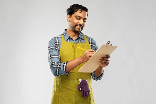 Happy indian gardener or farmer with clipboard — Stock Photo, Image