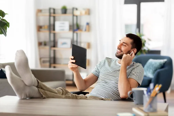 Homme heureux avec tablette PC et écouteurs à la maison — Photo