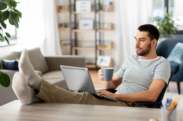 Uomo con computer portatile bere caffè a casa — Foto Stock
