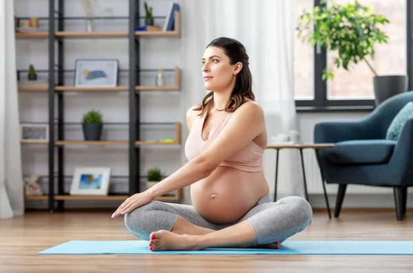 Happy pregnant woman doing yoga at home — Stock Photo, Image