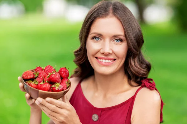 快乐的女人在夏季公园吃草莓 — 图库照片