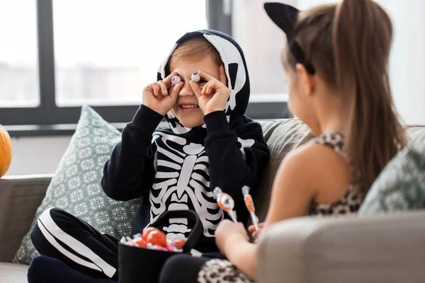 Crianças em trajes de Halloween com doces em casa — Fotografia de Stock