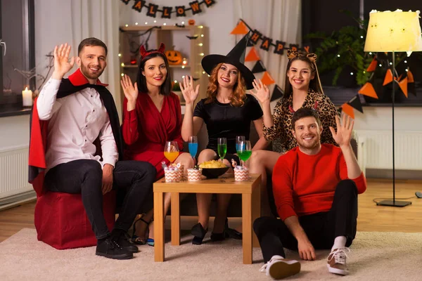 Amigos felices en disfraces de Halloween en la fiesta en casa —  Fotos de Stock