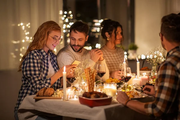 Amigos com celular tendo jantar em casa — Fotografia de Stock