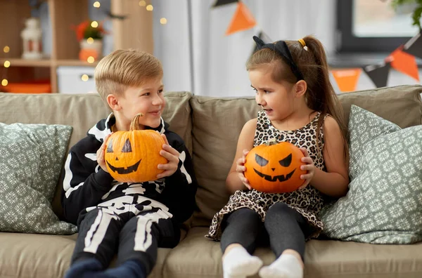 Enfants en costumes d'Halloween avec des citrouilles à la maison — Photo