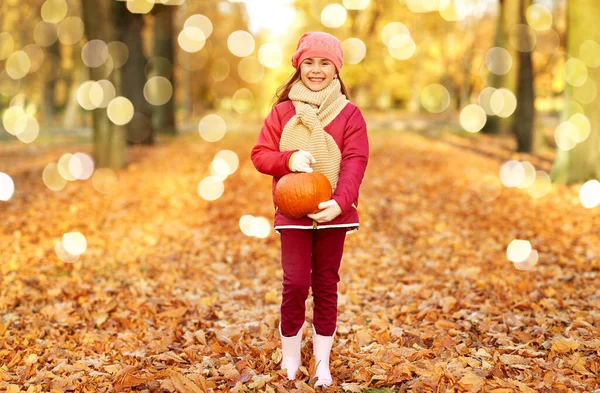 Ragazza felice con zucca al parco autunnale — Foto Stock