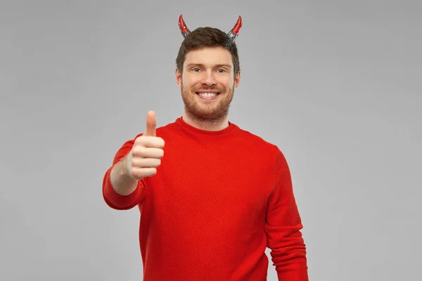 Hombre feliz disfrazado de diablo mostrando pulgares hacia arriba —  Fotos de Stock