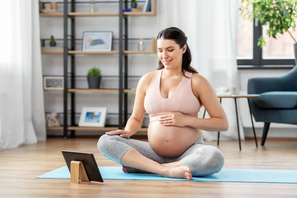 Femme enceinte avec tablette pc faire du sport à la maison — Photo