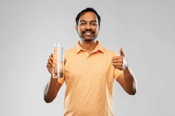 Férfi vízzel üveg mutatja hüvelykujját felfelé — Stock Fotó