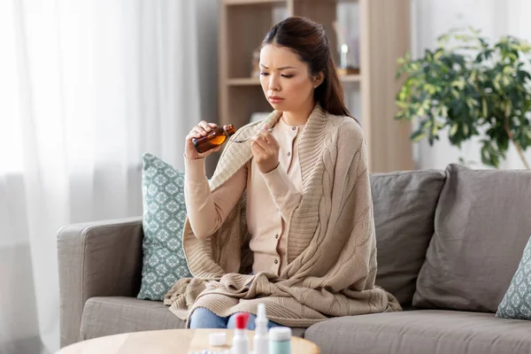 Sick asian woman taking medicine at home — Stock Photo, Image