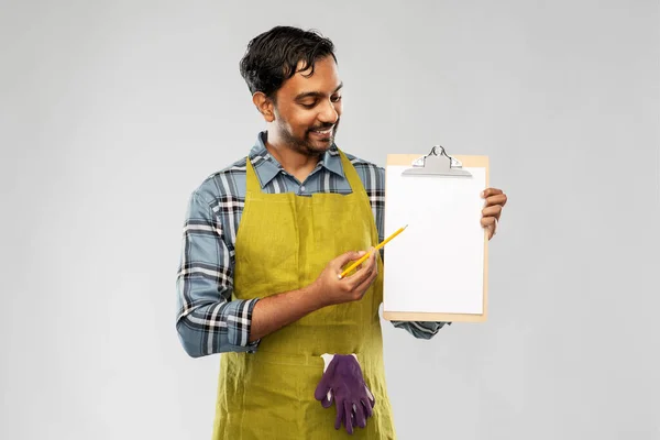 Happy indian gardener or farmer showing clipboard — Stock Photo, Image