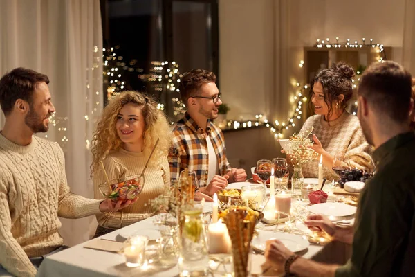 Amigos felices teniendo la cena de Navidad en casa —  Fotos de Stock