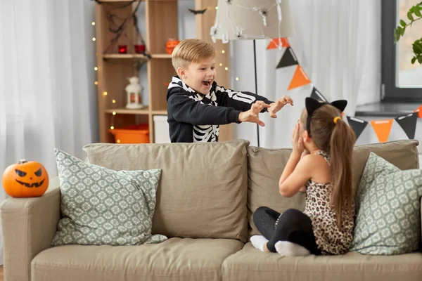 Crianças em trajes de Halloween jogando em casa — Fotografia de Stock