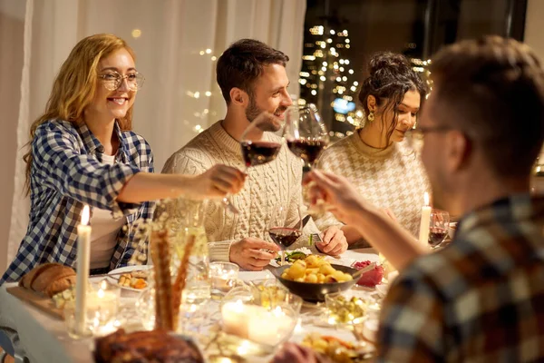 Amigos felizes bebendo vinho tinto na festa de Natal — Fotografia de Stock