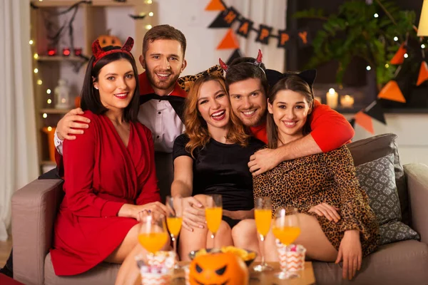 Amigos felizes em trajes de Halloween na festa em casa — Fotografia de Stock