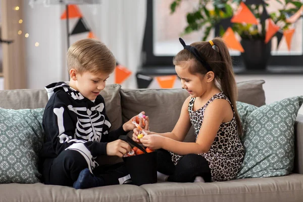 Ungar i halloween kostymer med godis hemma — Stockfoto