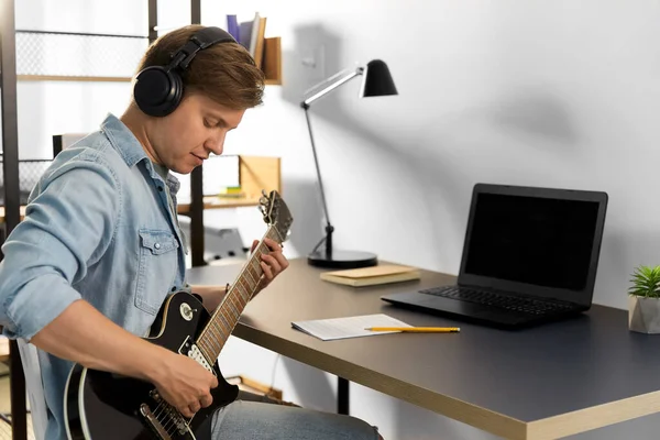 Man in headphones playing bass guitar at home — Stock Photo, Image