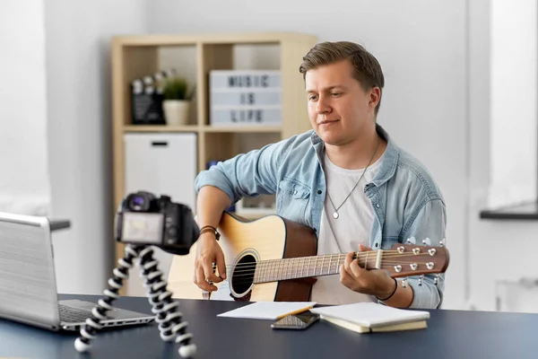 Hombre o blogger con cámara tocando la guitarra en casa — Foto de Stock