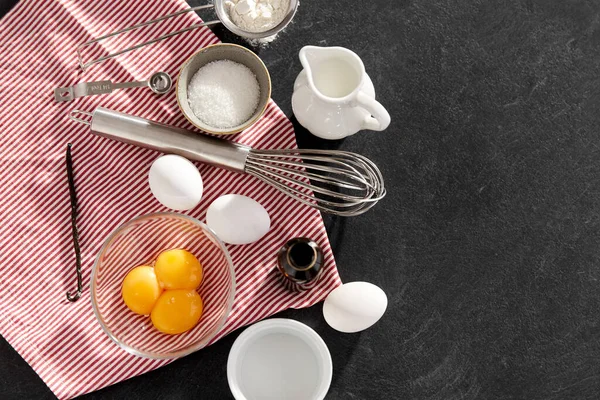 Whisk, ovos, açúcar, leite, farinha e baunilha — Fotografia de Stock