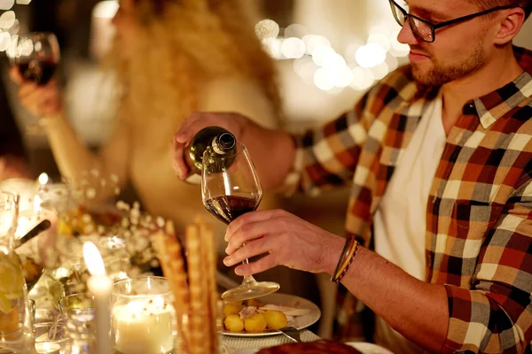 Mann schüttet bei Weihnachtsfeier Rotwein ins Glas — Stockfoto