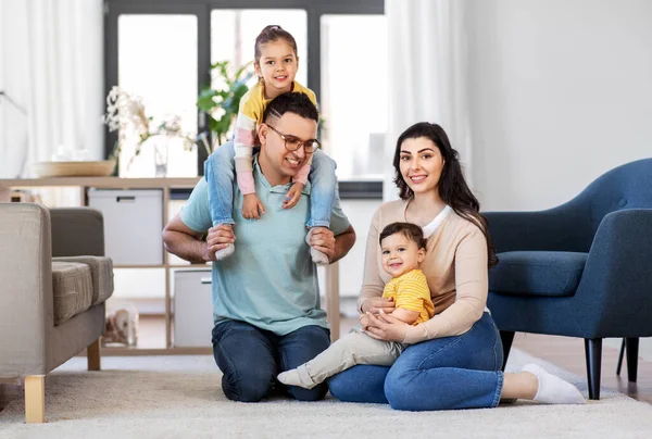 Portrait of happy family sitting on floor at home — Stock Photo, Image