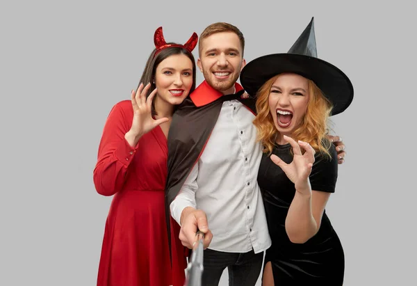 Amigos felices en disfraces de Halloween tomando selfie — Foto de Stock