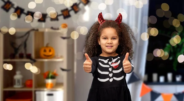 Girl in black dress and devils horns on halloween — Stock Photo, Image