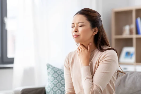 Sick asian woman with sore throat at home — Stock Photo, Image