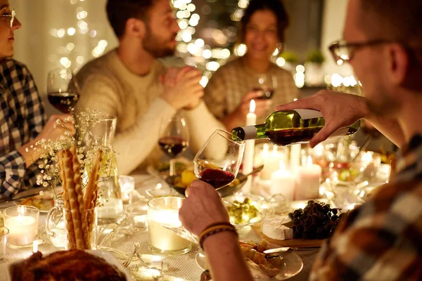 Mann schüttet bei Weihnachtsfeier Rotwein ins Glas — Stockfoto