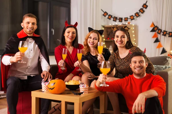 Amigos felizes em trajes de Halloween na festa em casa — Fotografia de Stock