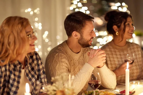 Amigos felices teniendo la cena de Navidad en casa —  Fotos de Stock