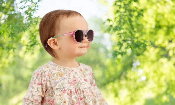 Happy little baby girl in sunglasses over nature — Stock Photo, Image