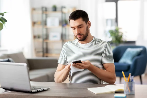 Mann putzt Telefon mit Feuchttüchern im Home Office — Stockfoto